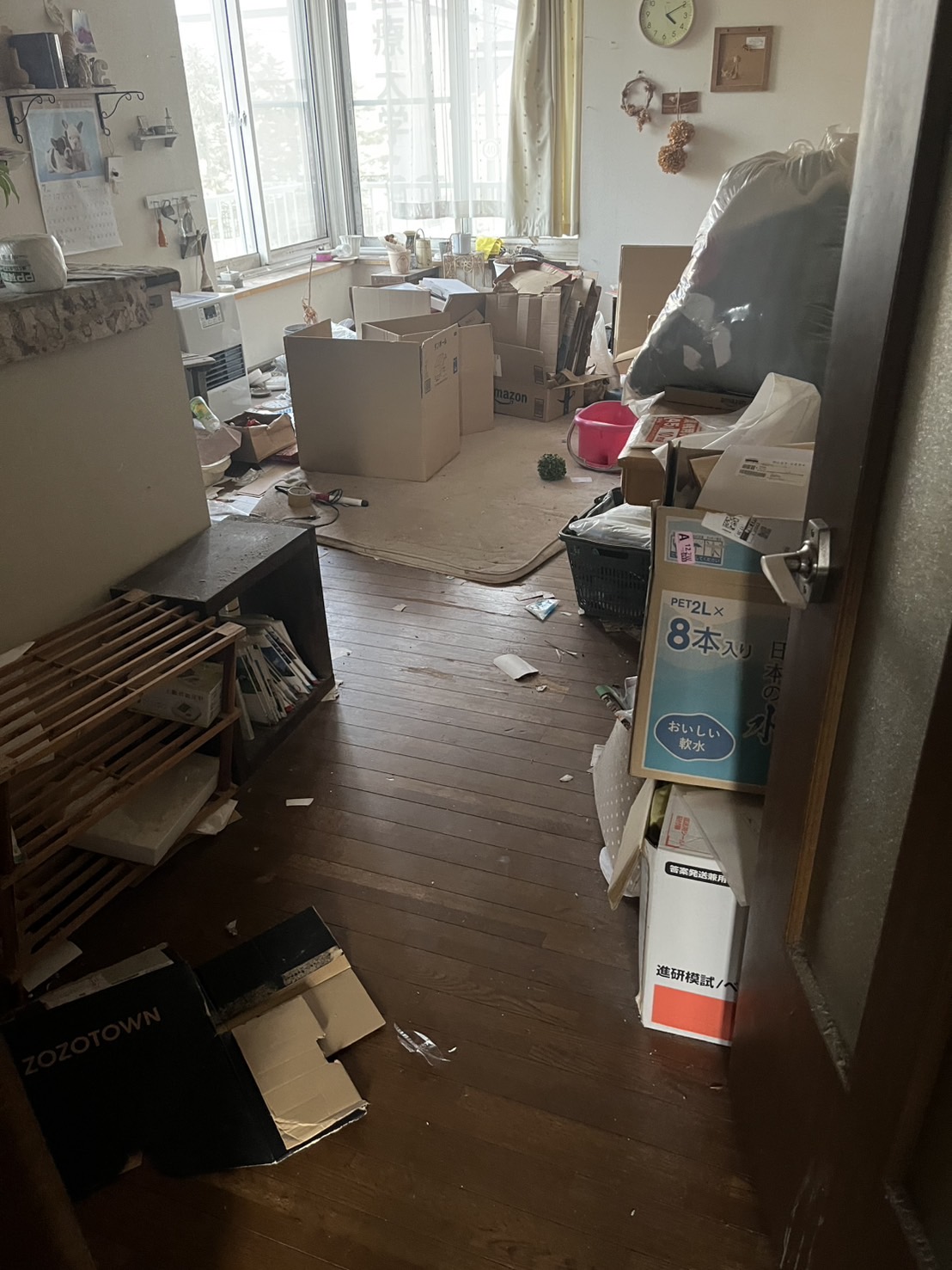 札幌市の不用品回収 リビングに荷物・段ボールが積まれた片付け前の状態